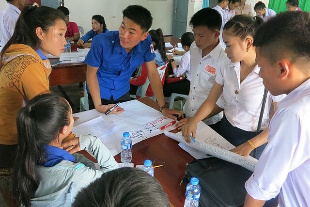 Bewohner von Laos stehen um einen Tisch für ein Blutspende-Training