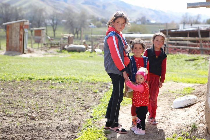 Kindergruppe steht in kirgisischem Garten 